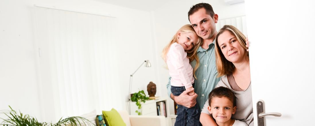 Eine Familie steht an einer geöffneten Tür
